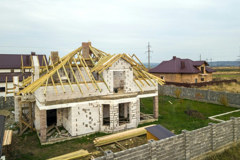 Aerial view of a private house with aerated concrete brick walls and wooden frame for future roof.