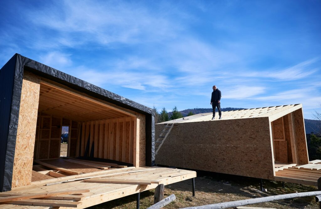 Man inspecting quality of building wooden frame house.