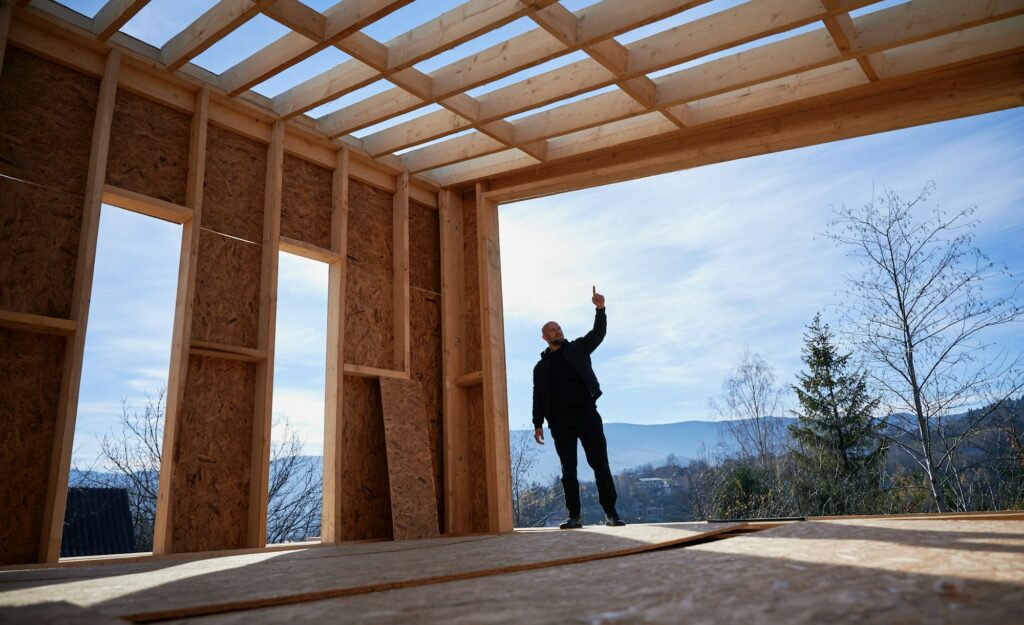 Man inspecting quality of building wooden frame house.