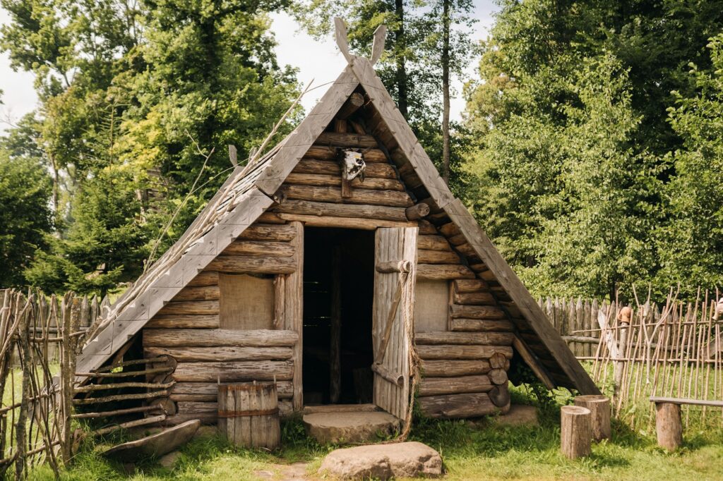 Triangular log houses with wooden roofs behind a fence. Montenegro, north